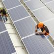 Two men working on repairing solar panels